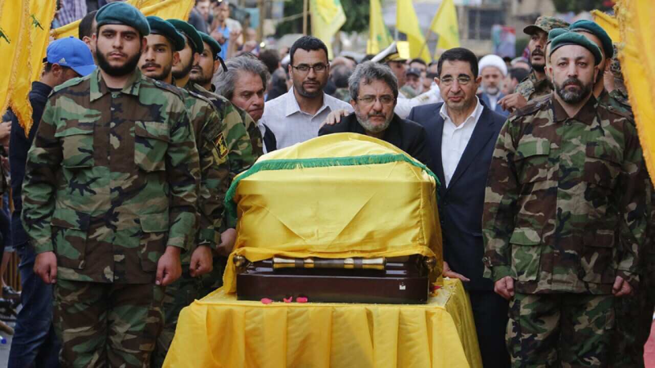 Hezbollah members carry the coffin of commander Mustafa Badreddine
