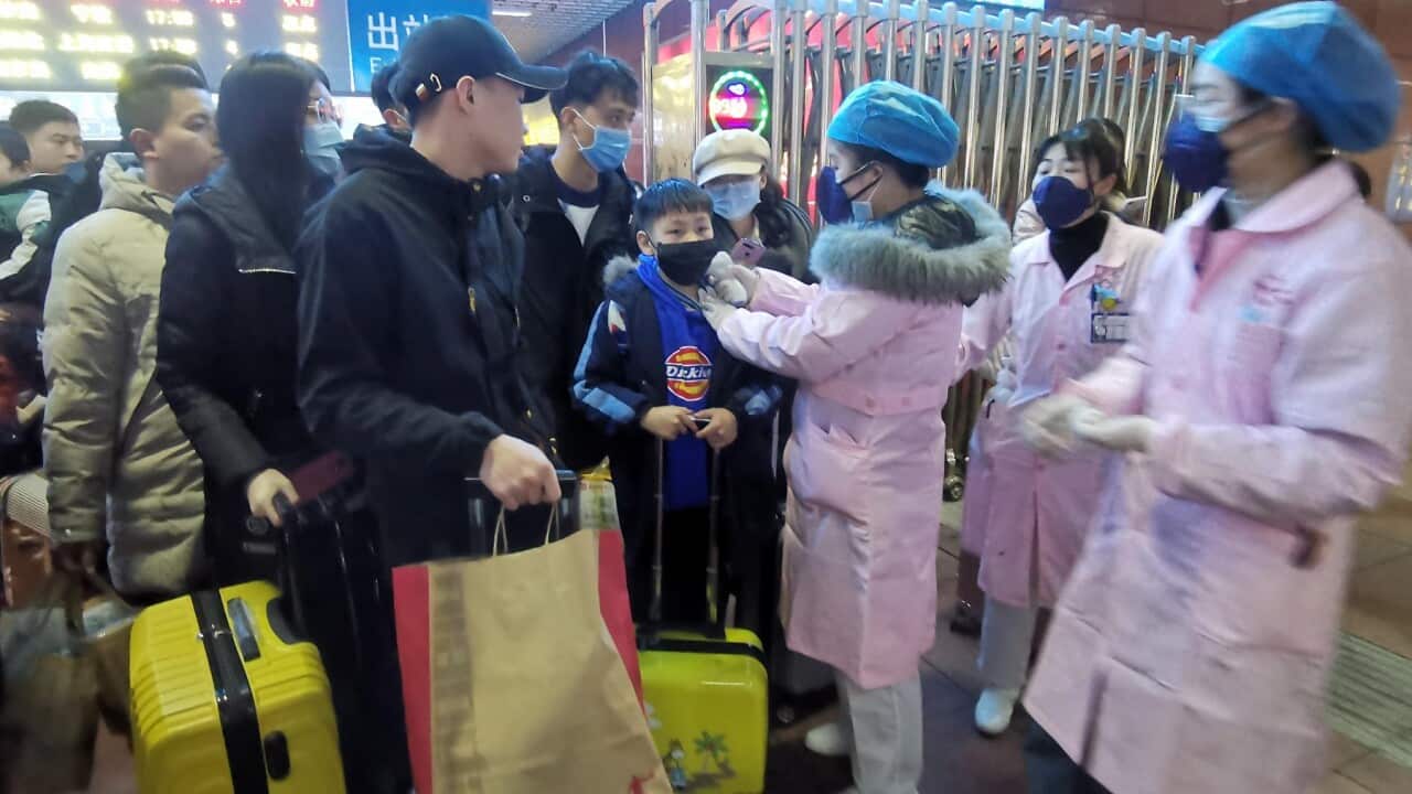 Medical staff check the body temperature of passengers as they arrive at a railway station in Yingtan City, Jiangxi province, China, 22 January 2020.