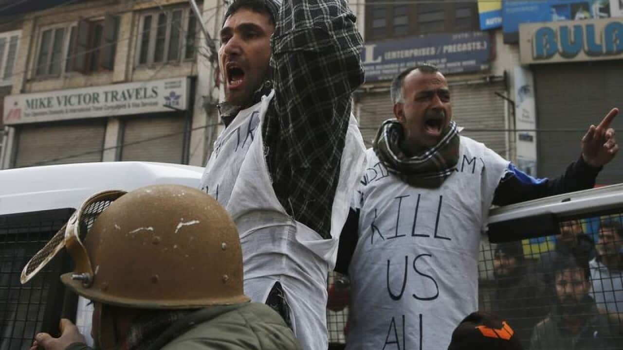 Indian policemen detaining Kashmiri protestors