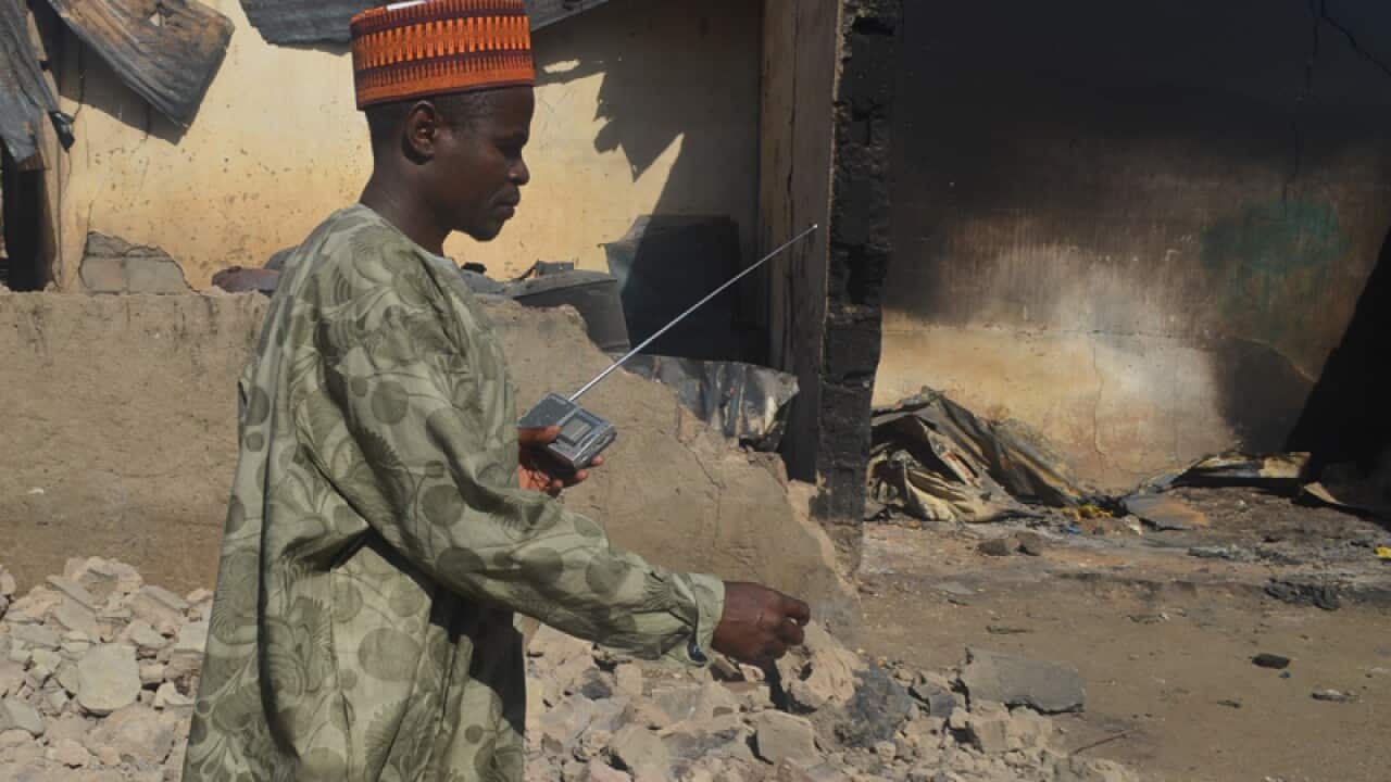 A man walks past a burnt out building after an attacked by Boko Haram