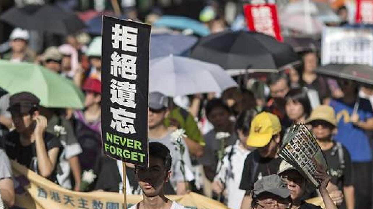 Protesters hold placards during a march for democracy in China, in Hong Kong, 01 June 2014.
