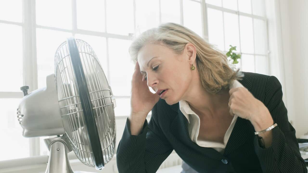 Hot businesswoman sitting in front of fan