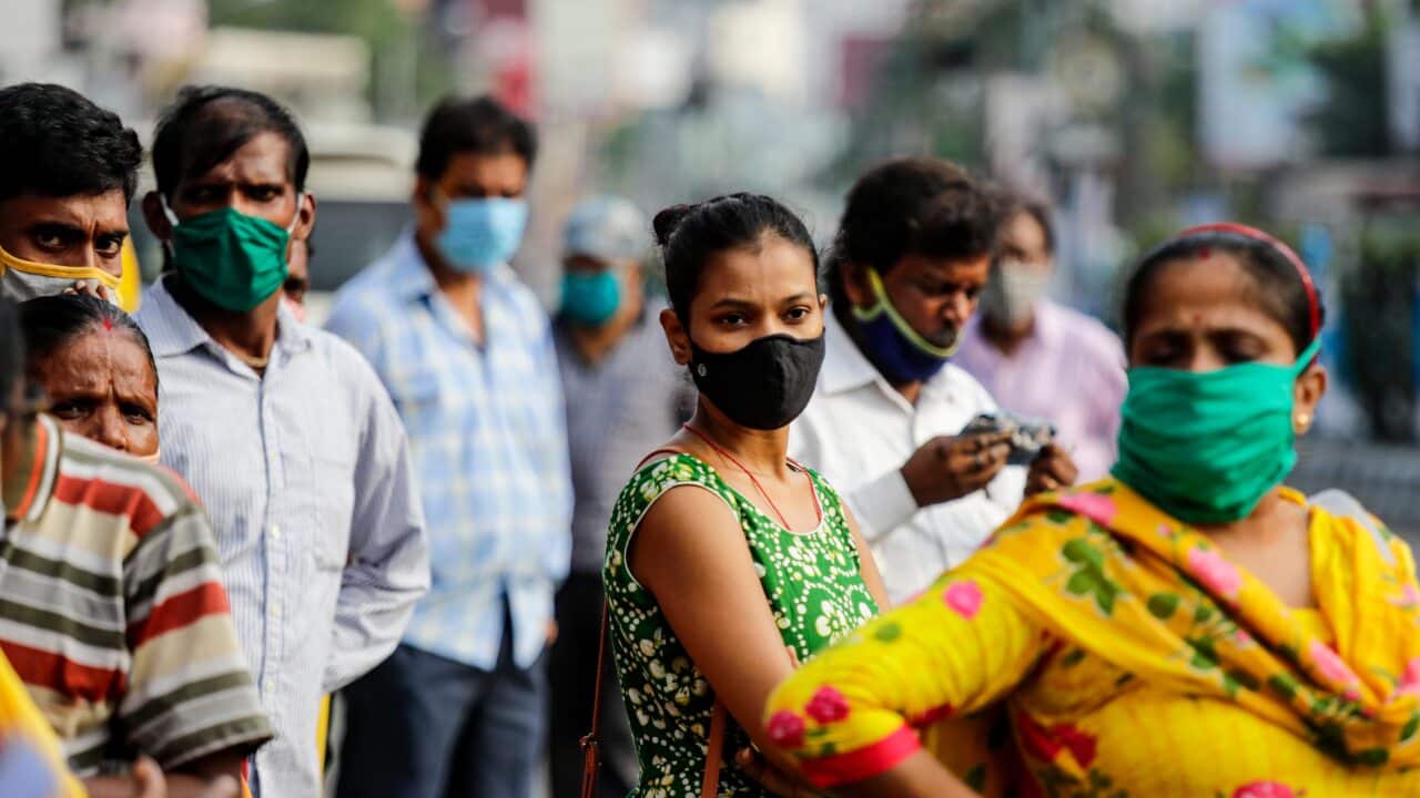 Commuters wait for a bus in Kolkata, India