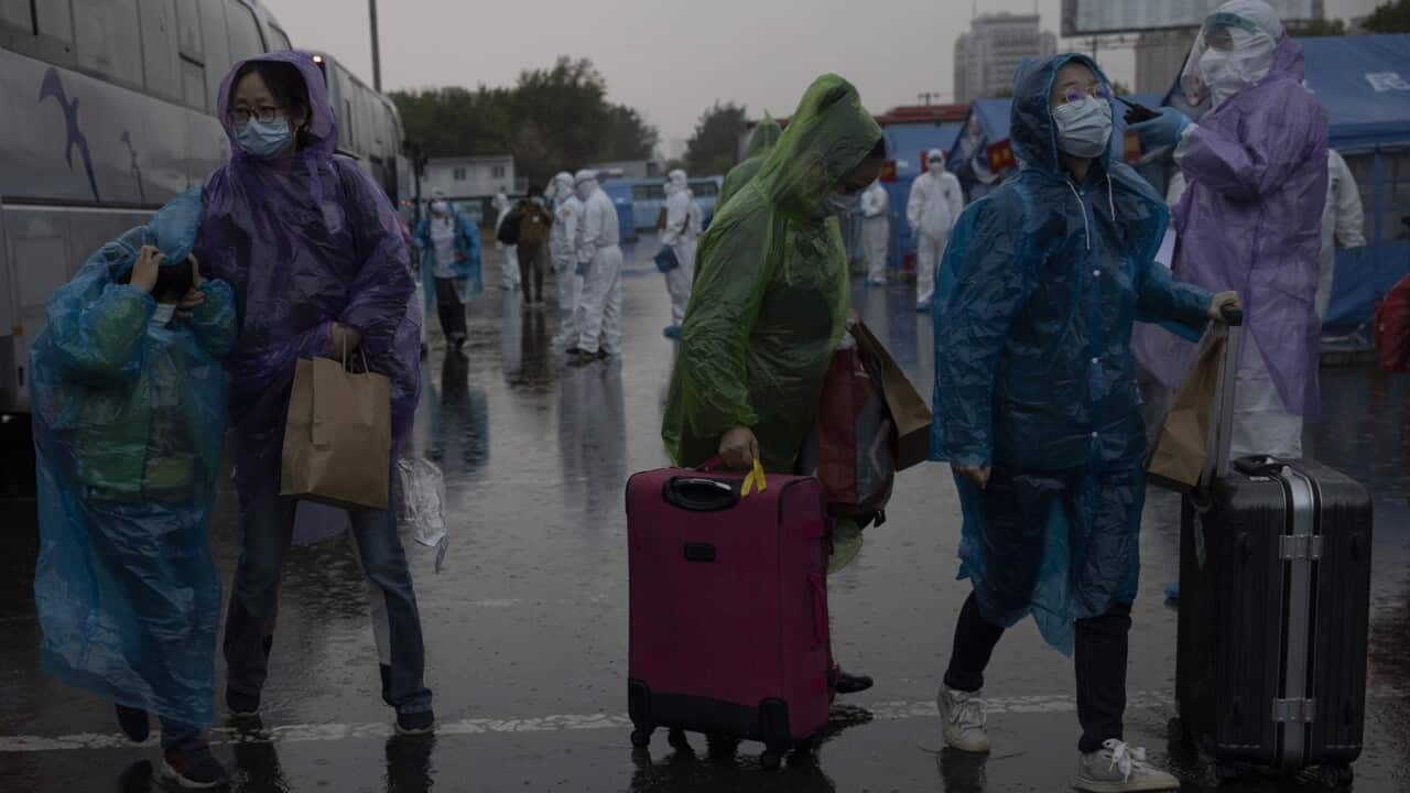 Travelers from Wuhan are processed upon arriving by high speed train in Beijing