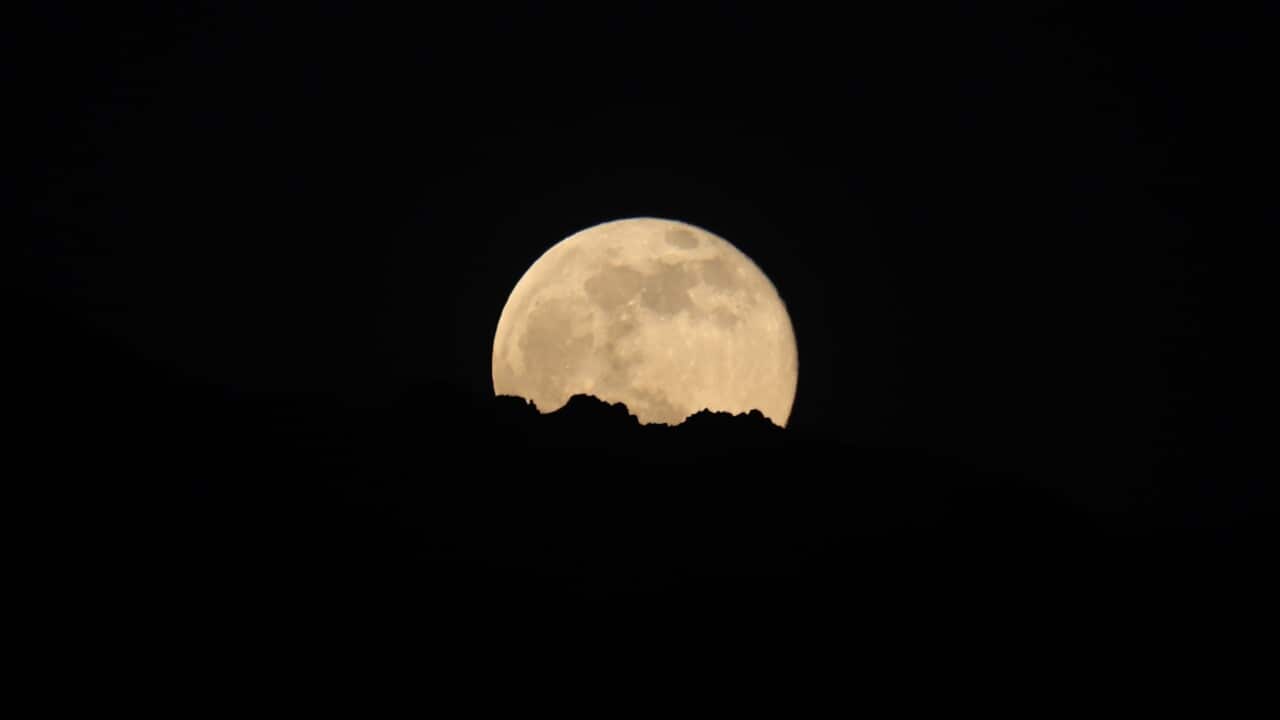 Supermoon rising over city skyline