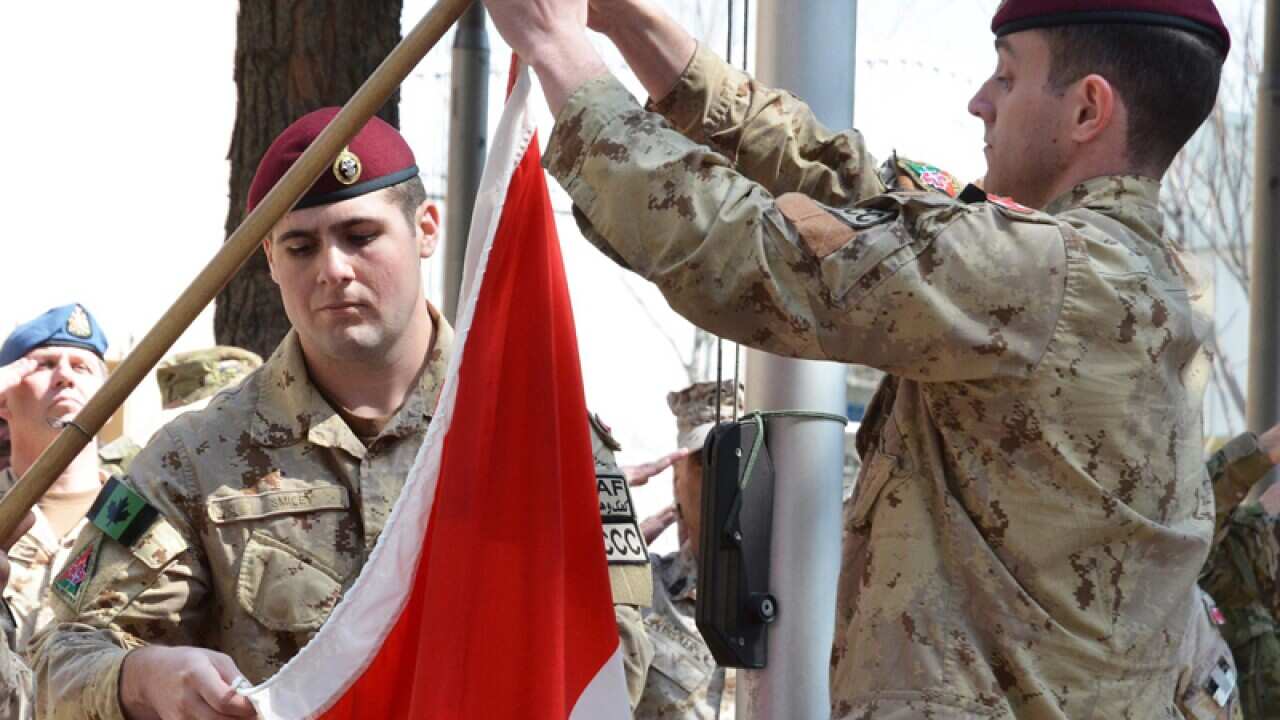 A Canadian soldier is greeted by a woman