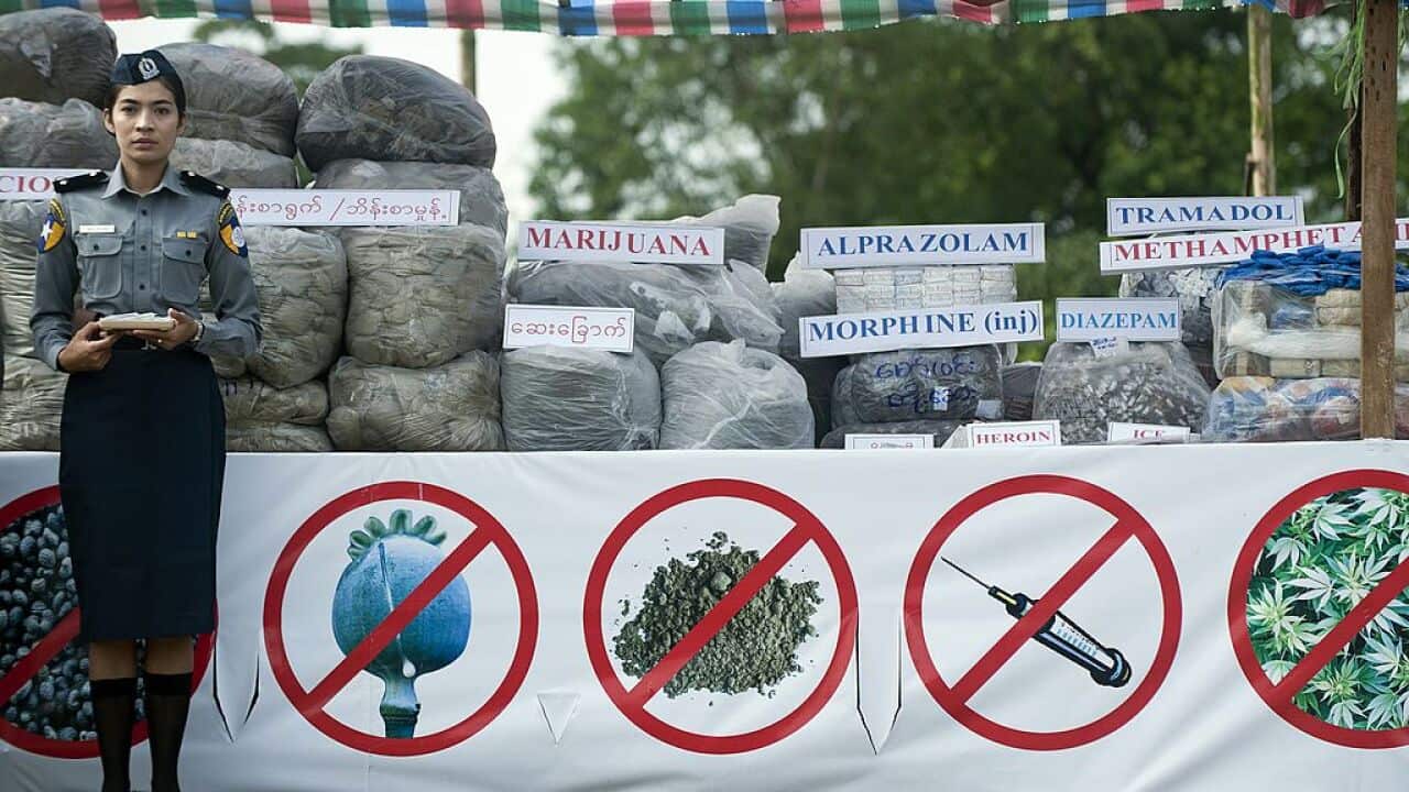 A policewoman stands beside seized drugs during a destruction ceremony marking the UN's international day against drug abuse and illicit trafficking in Myanmar.