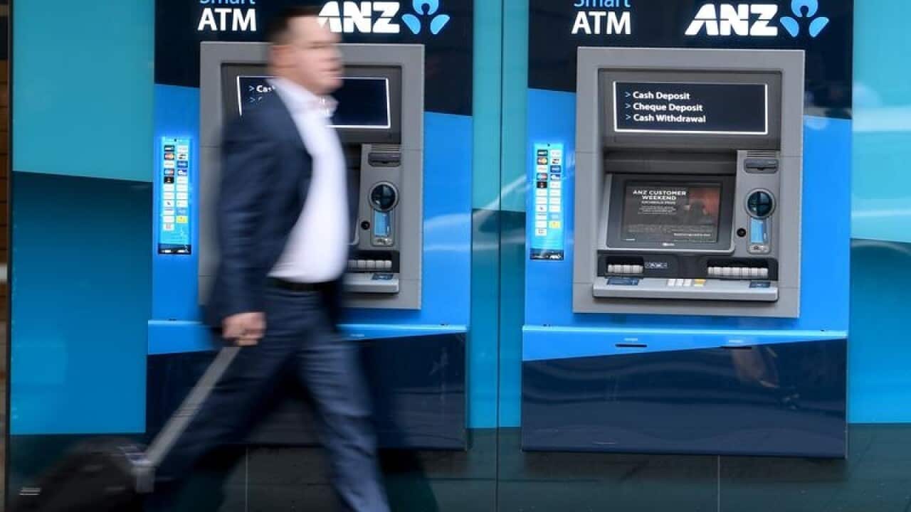 A pedestrian walks past an ANZ bank branch