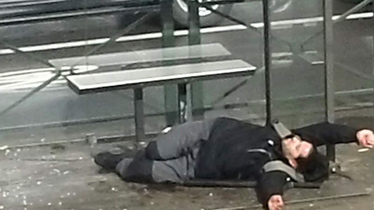 An injured man lays on the floor at a tram stop in Brussels
