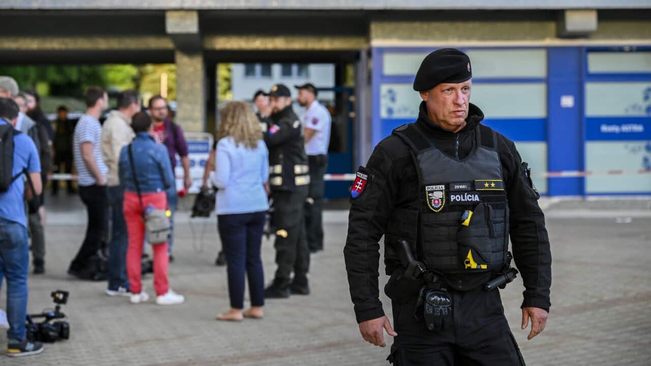 A police officer stands in the foreground