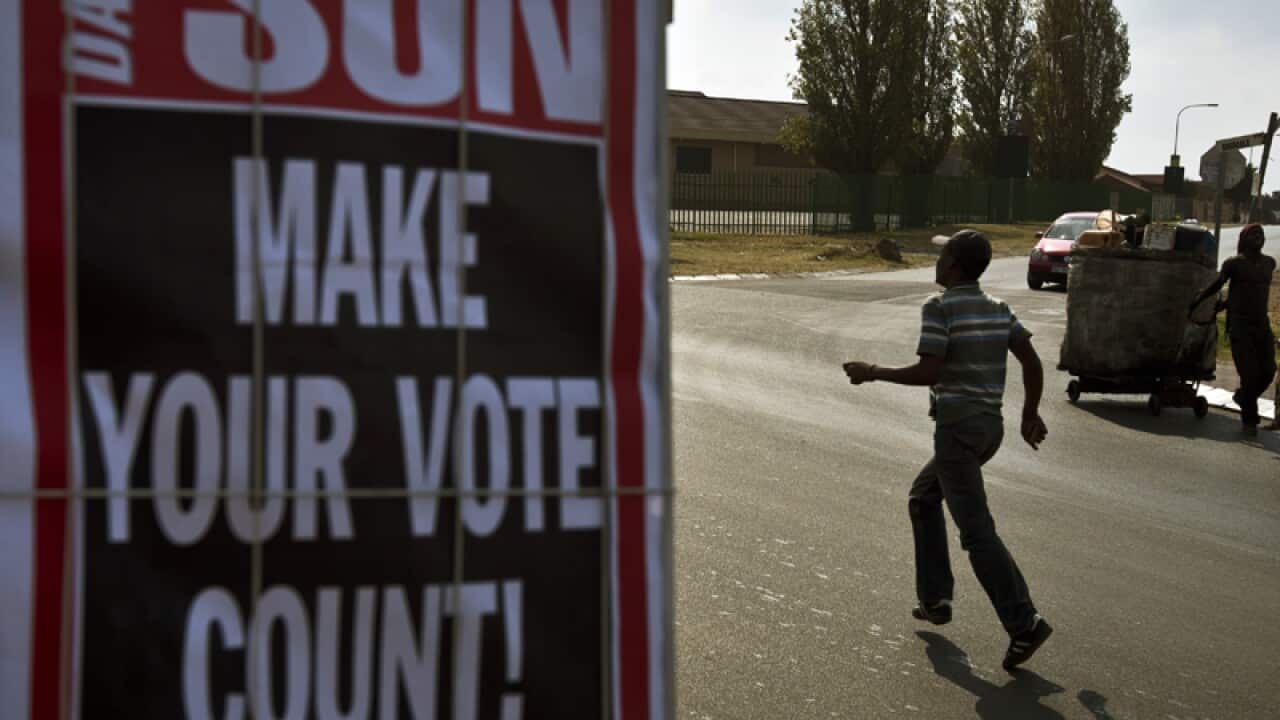 A man runs past a placard urging people to vote