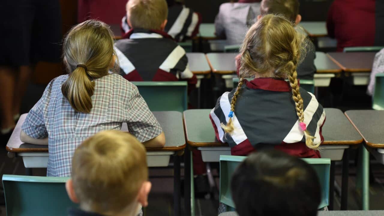 Children sit in a classroom during a lesson