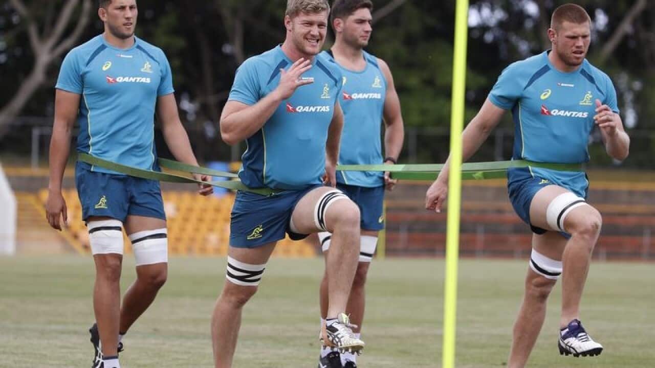 Matt Philip (2nd L) and Blake Enver stretche during training session.