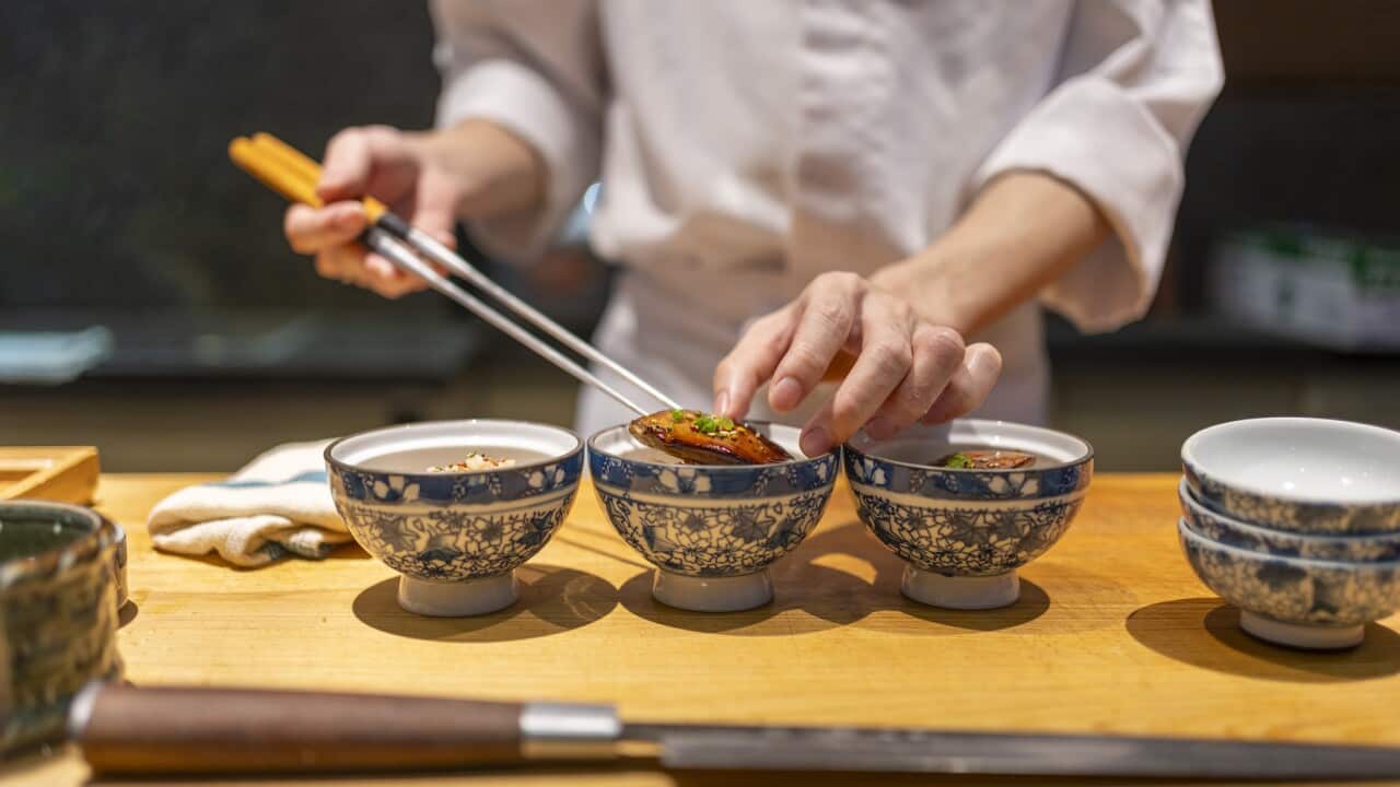 Chef uses saibashi chopsticks to make a meal.