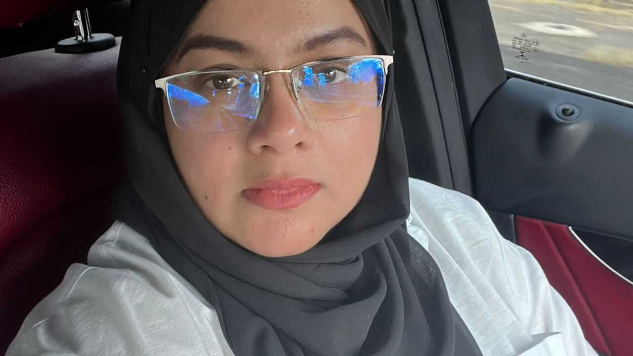 A woman in a headscarf looks at the camera