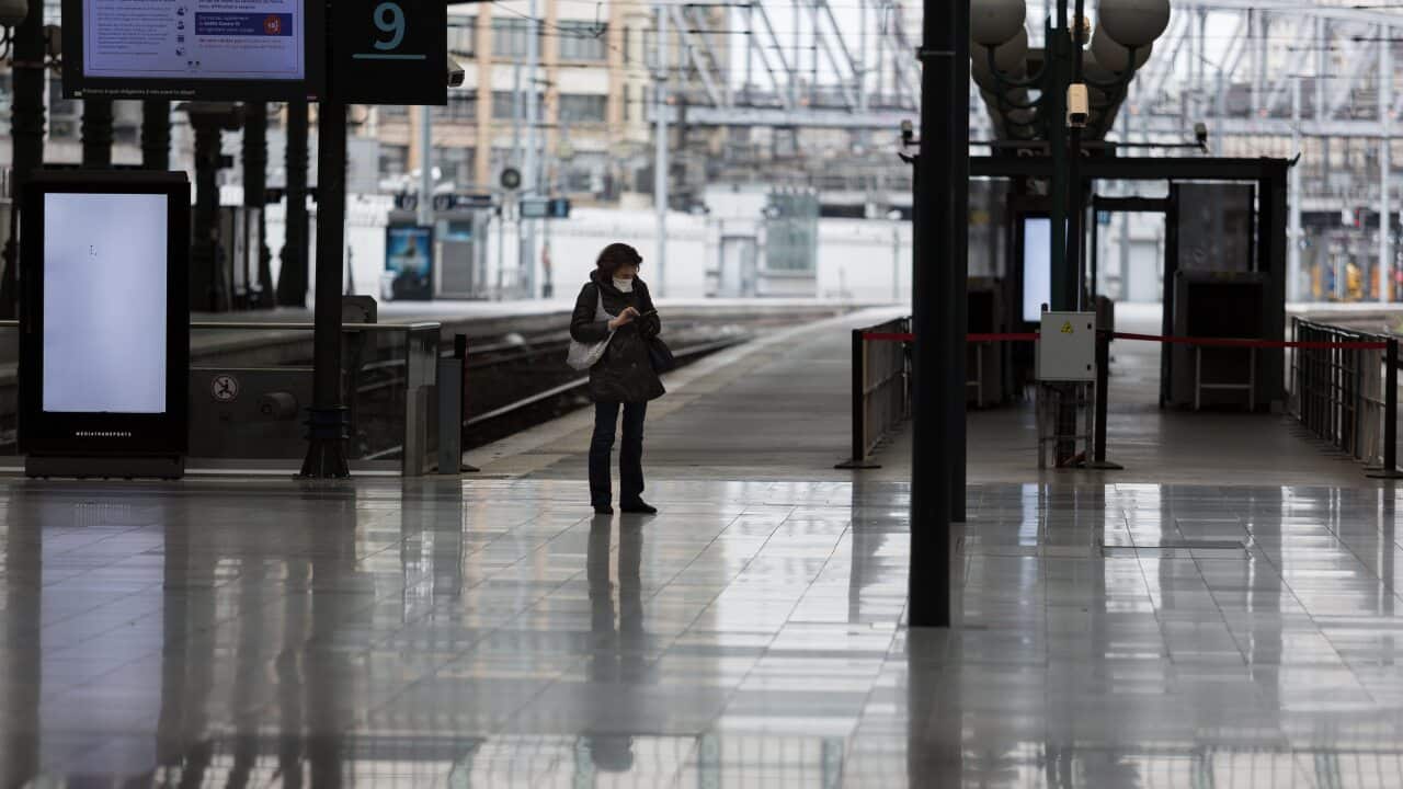 A woman wearing a face mask stands in a desolate Gare du Nord train station in Paris, France on Saturday.