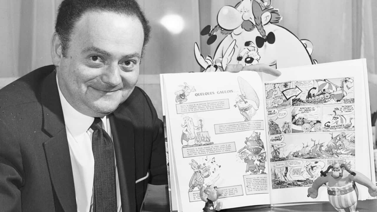 Rene Goscinny displays samples of his comic strip "Asterix the Gaul"
