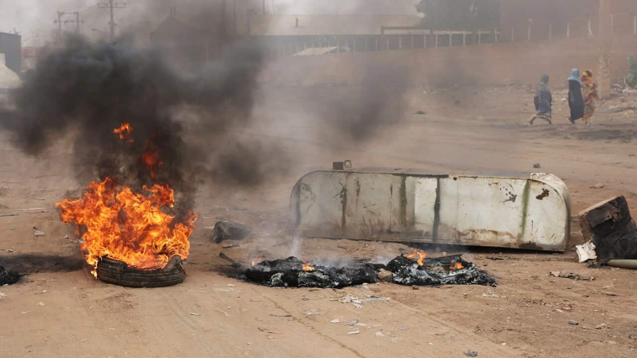 A tire burns at a roadblock in the center of Khartoum, Sudan.