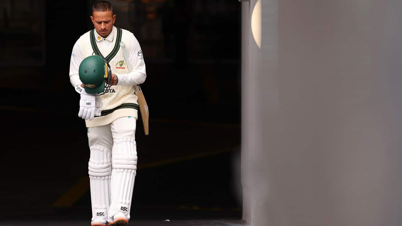 Usman Khawaja walks out of the players tunnel in full cricket gear.