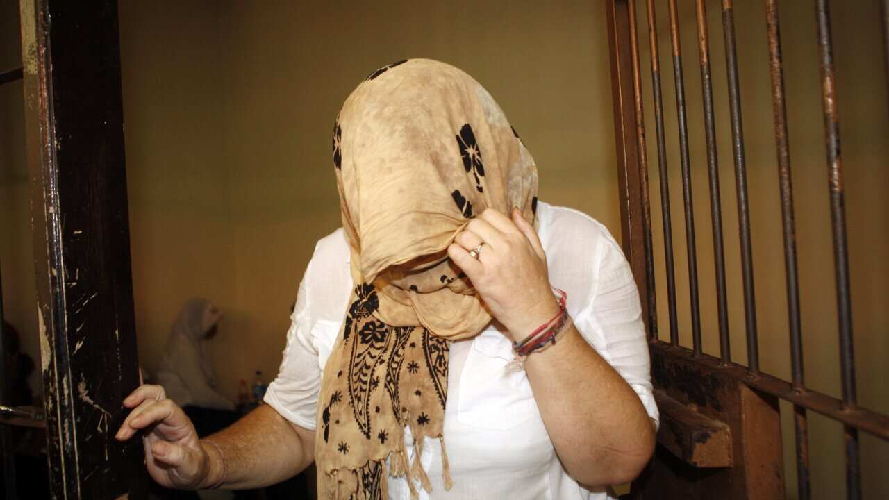 British alleged drug trafficking suspect Lindsay Sandiford has her face covered inside a holding cell before her verdict trial at Denpasar district court in Bali, Indonesia, 22 January 2013. (AAP)