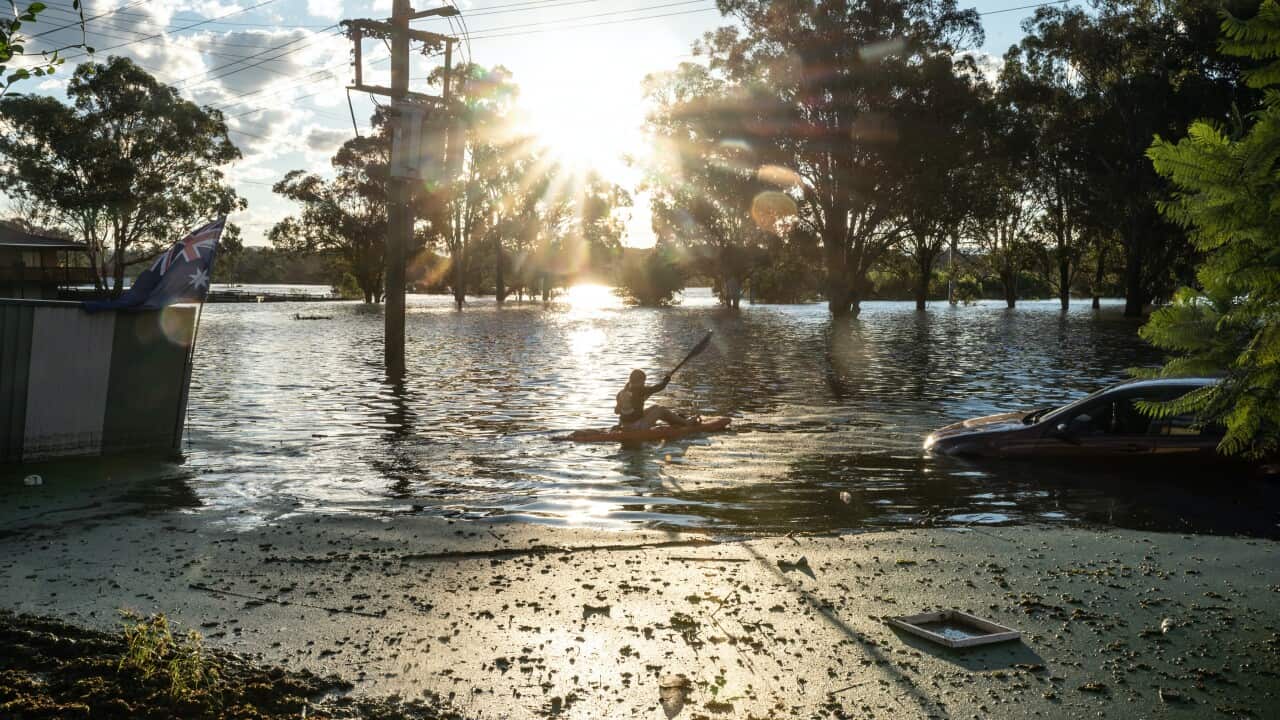 A girl paddles through floodwaters in South Windsor, Sydney, on Wednesday, 24 March.