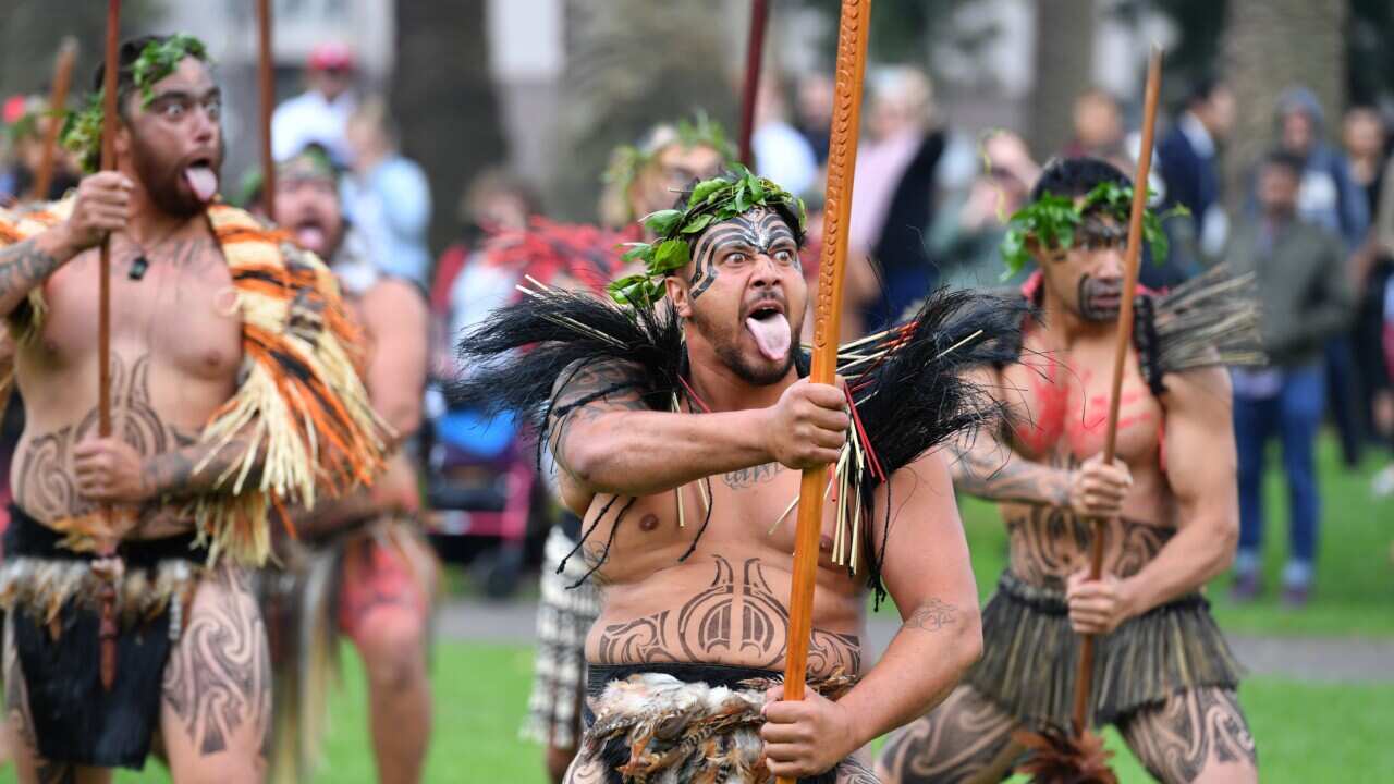 Three men perform a haka.