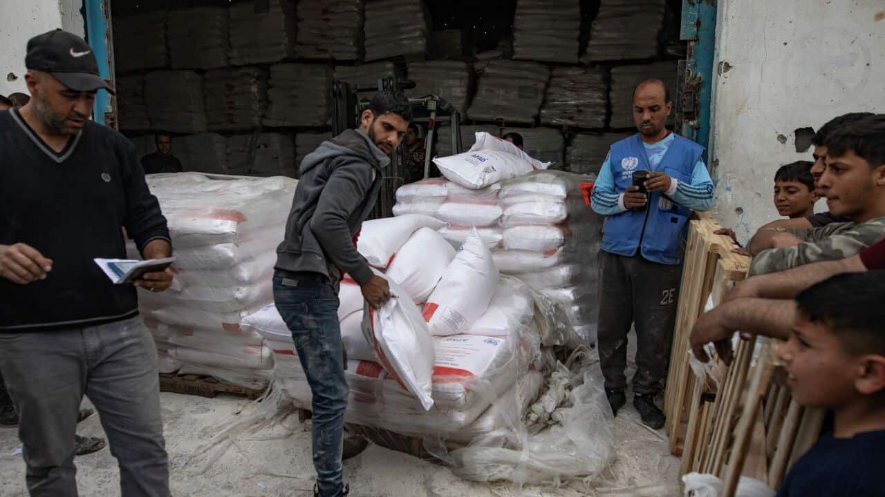 Internally displaced Palestinians gather at a flour distribution point after bakeries closed, in Gaza City, 01 April 2025. Credit: AAP/EPA/HAITHAM IMAD.