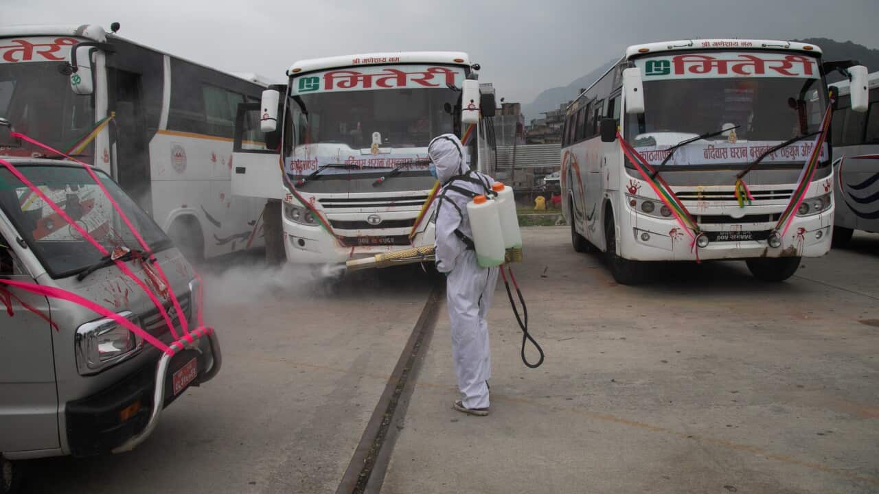 A worker in personal protective equipment suite (PPE) disinfects a public vehicle as a preventive measure against the spread of Coronavirus in Nepal.
