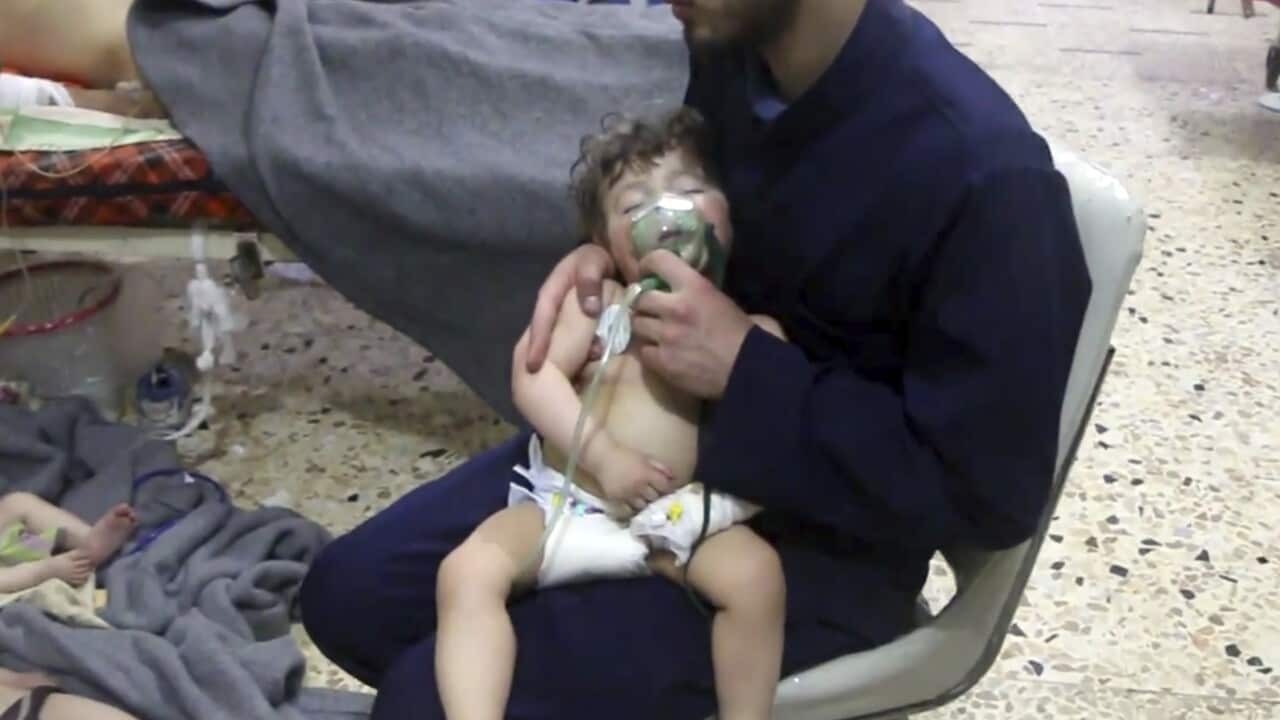 A medical worker giving toddlers oxygen through respirators following an alleged poison gas attack in the opposition-held town of Douma