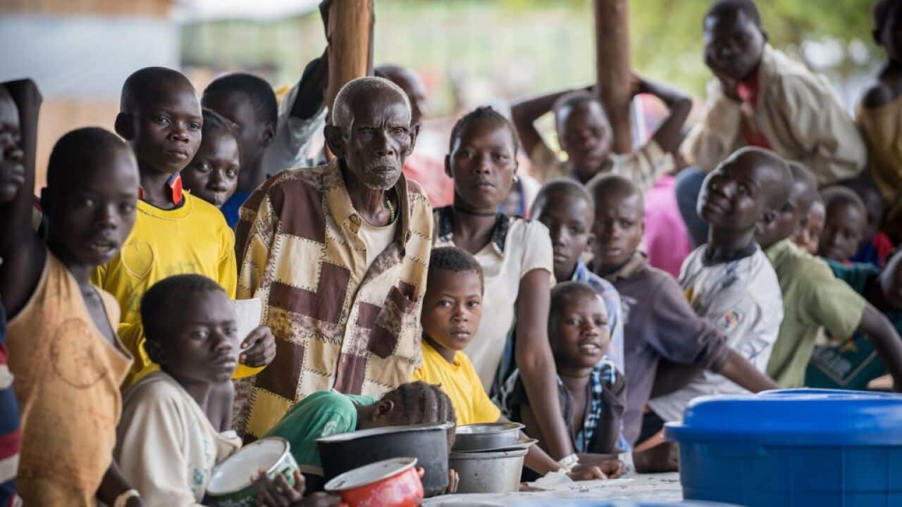 Newly arrived Congolese refugees seen waiting for their food