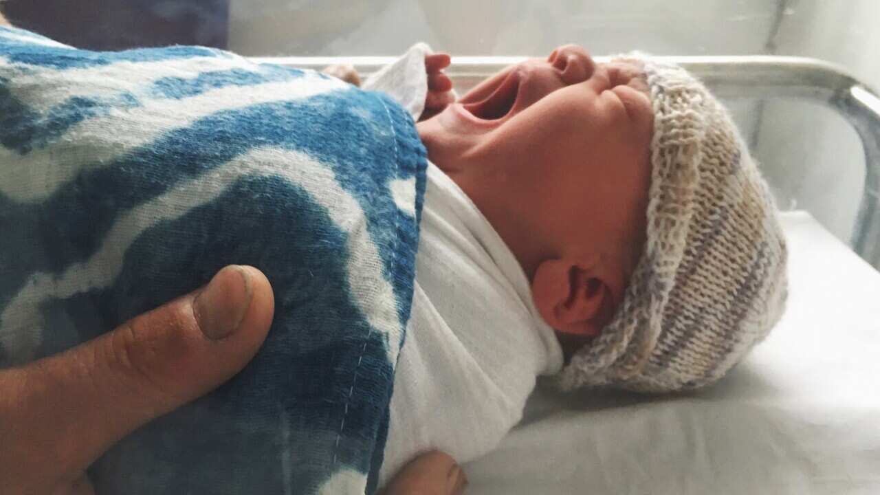 Fathers hands holding newborn baby