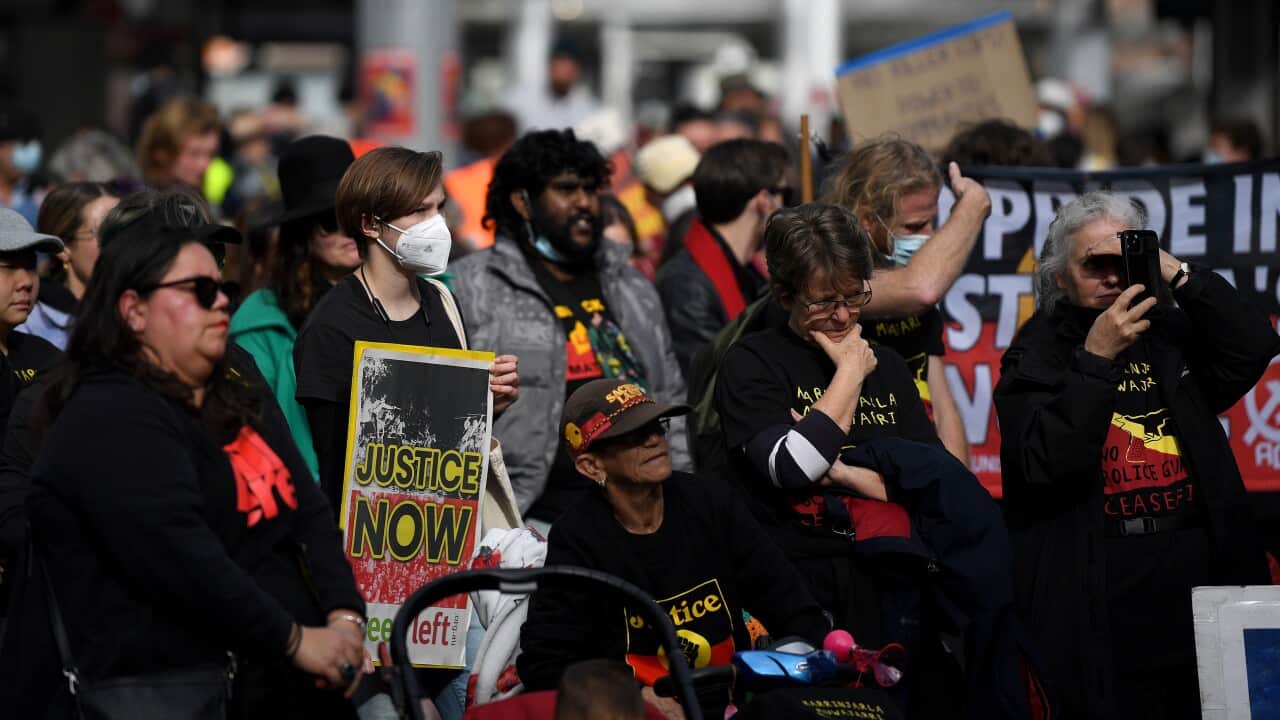 A group of protesters holding signs about Indigenous deaths in custody.