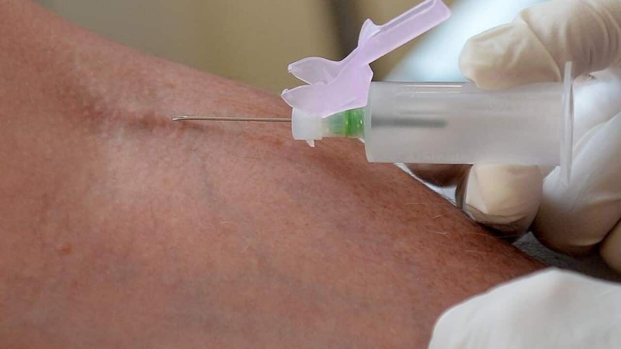 A nurse takes blood from a patient
