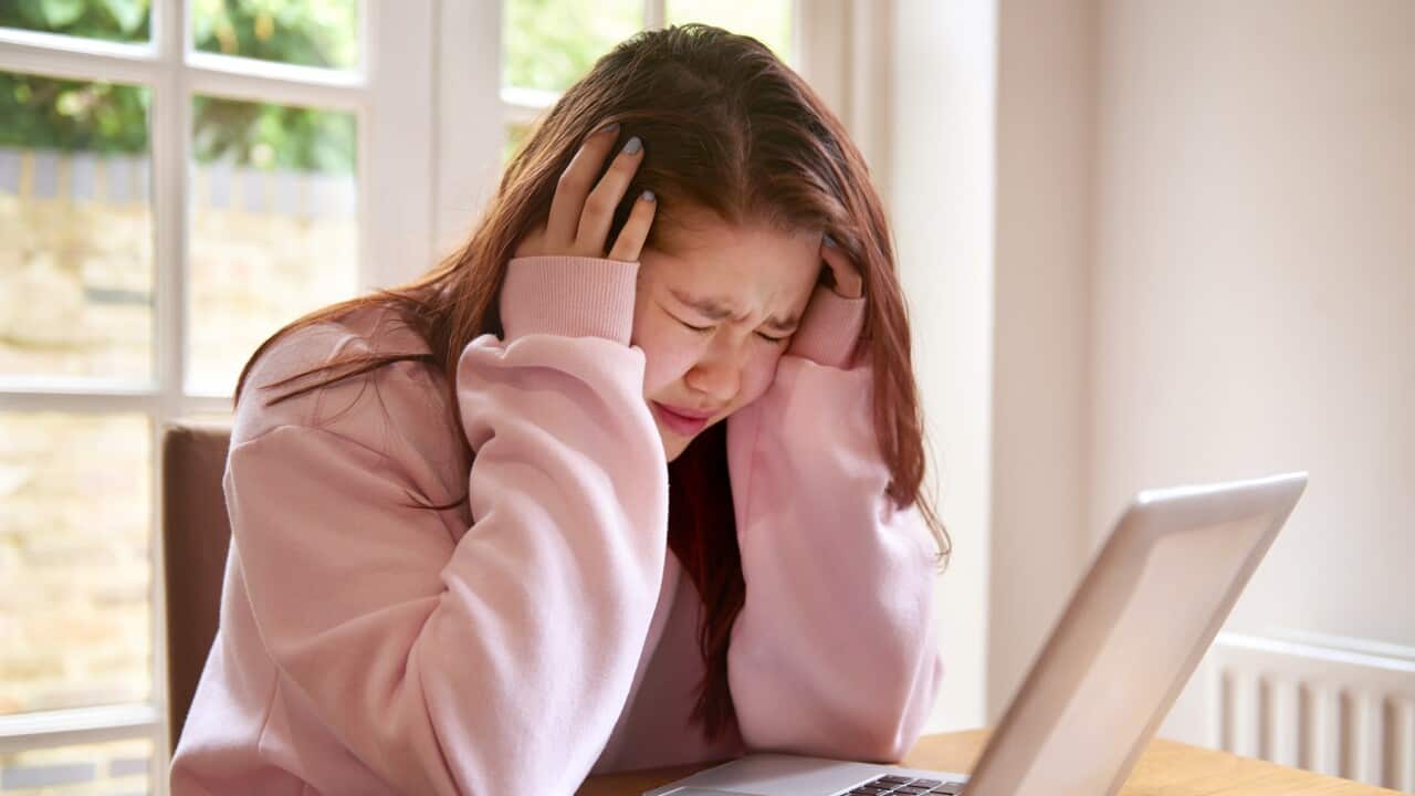 Teenager crying using laptop