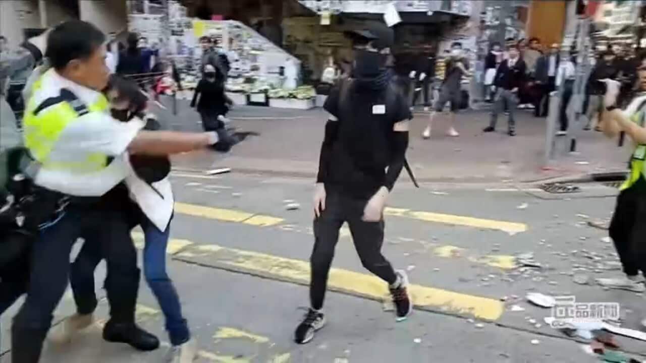 Hong Kong police officer shoots protester in street.