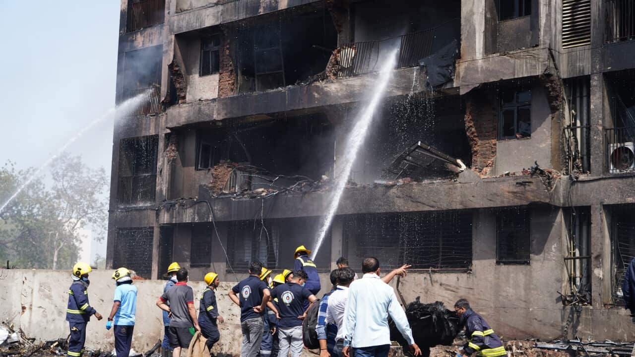 Firefighters spray a burnt out building