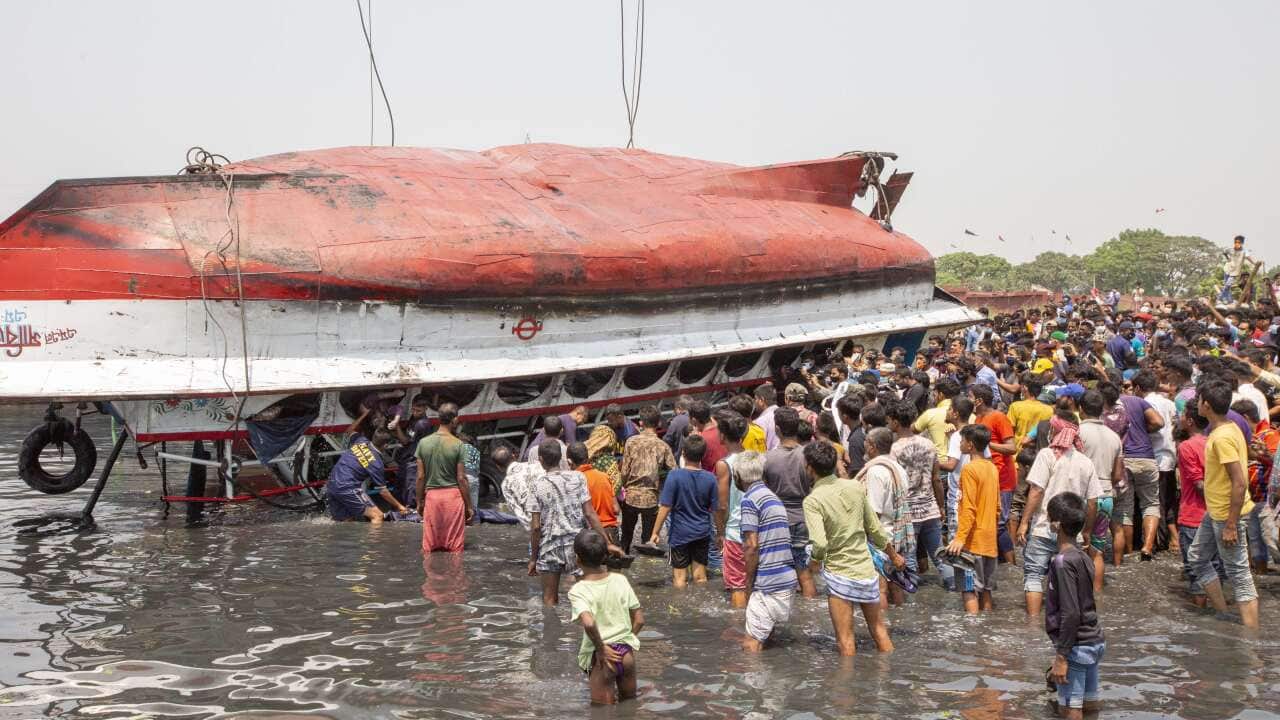 Local people look a capsized ferry boat after it capsized in the Shitalakkhya river in Dhaka, Bangladesh.