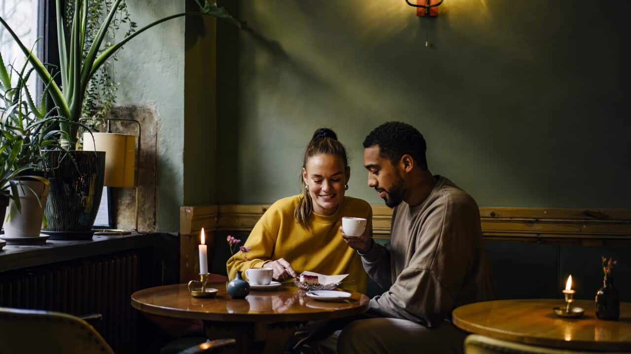 Wide shot with copy space of couple sharing a dessert in cafe