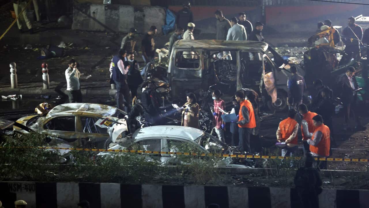 Indian police personnel inspect the scene of a blast near the red fort in New Delhi