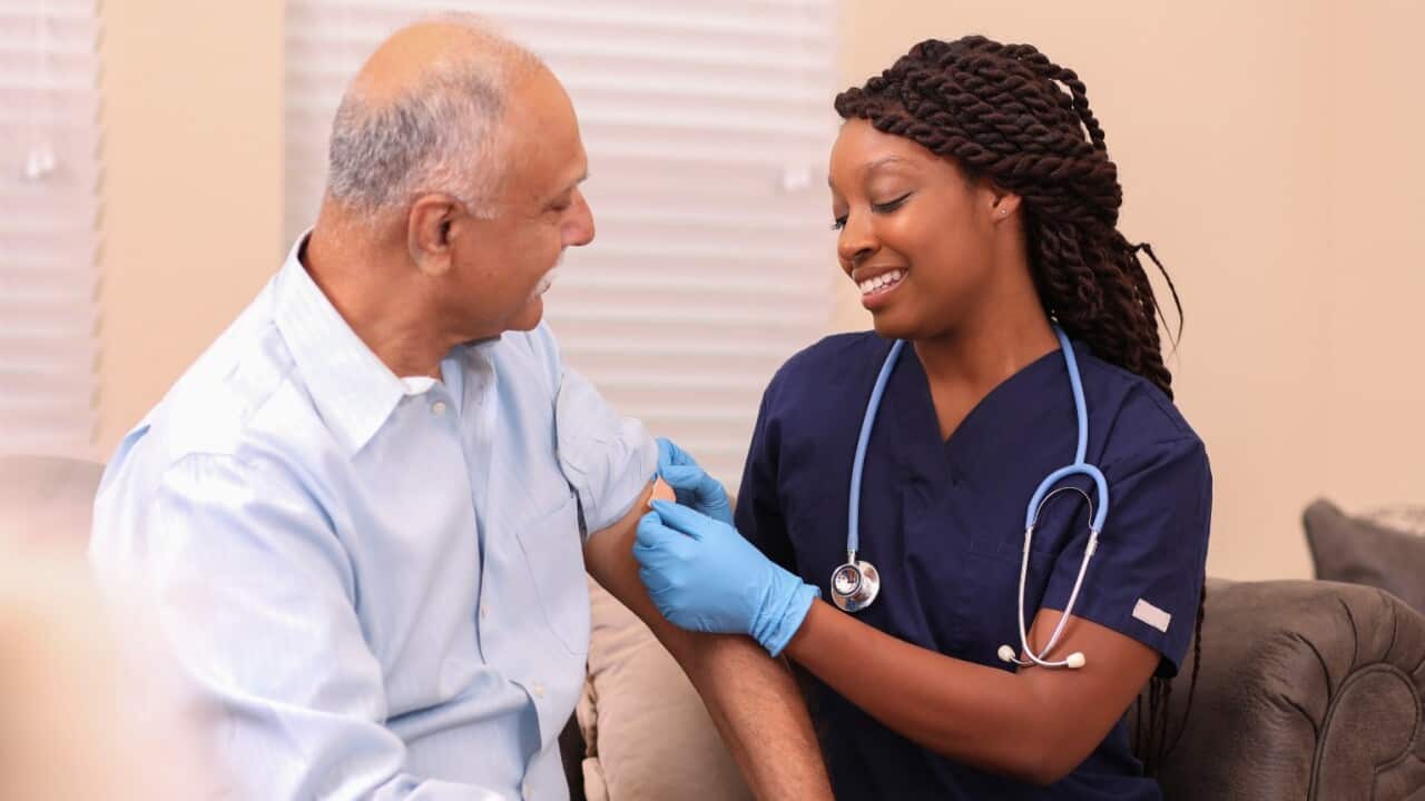 Older man getting shot from nurse