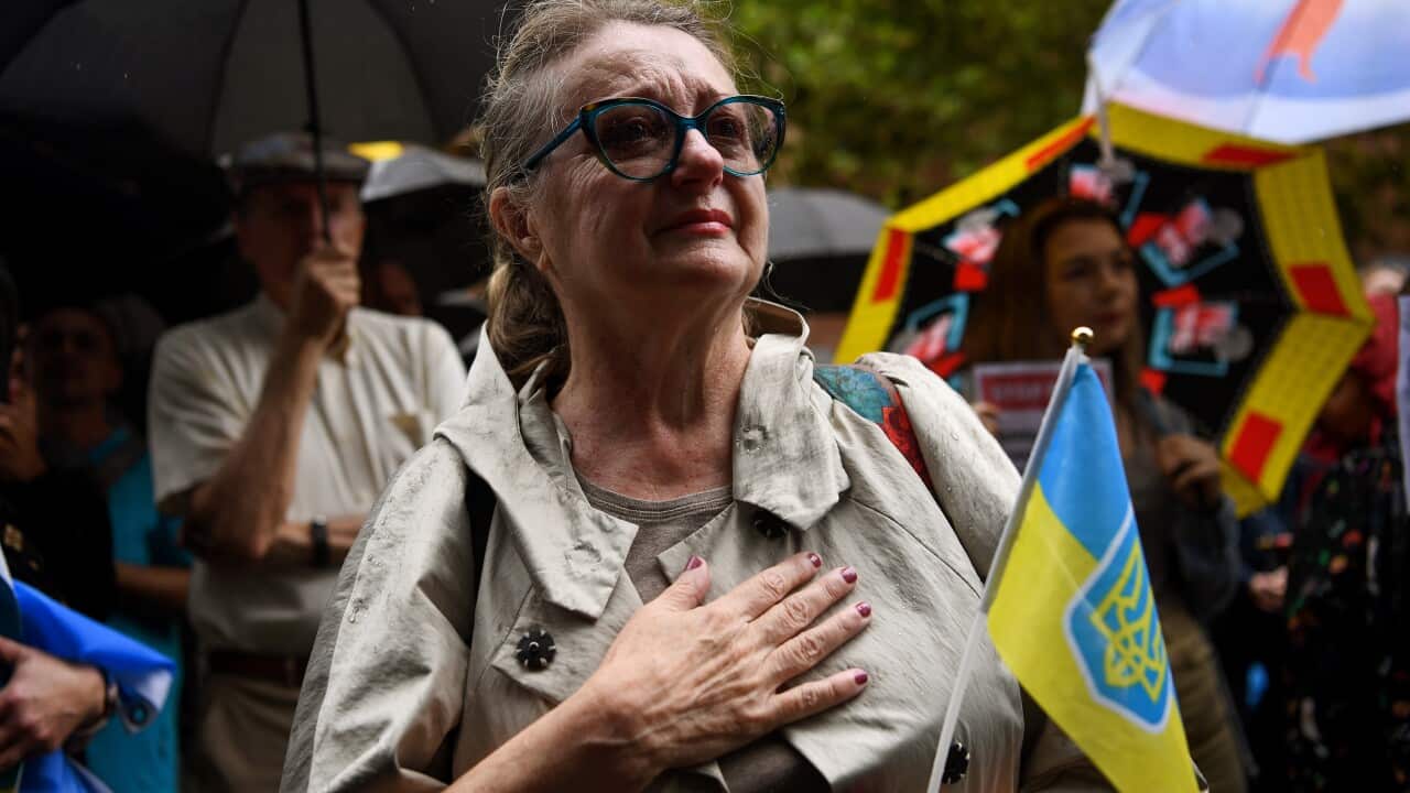 Protesters hold placards and Ukrainian flags during a rally at Martin Place in Sydney, Friday, 25 February, 2022.