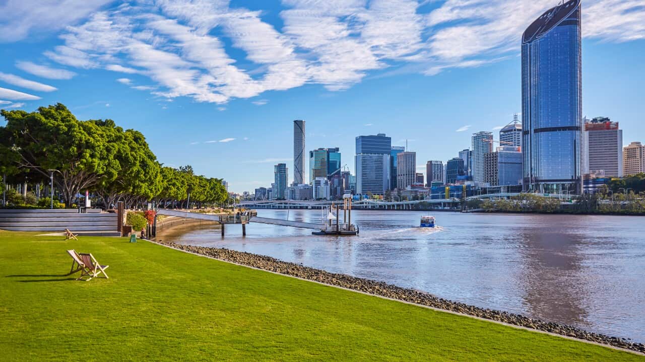People sunning themselves on public chairs in parkland at Southbank Brisbane, Queensland, Australia.