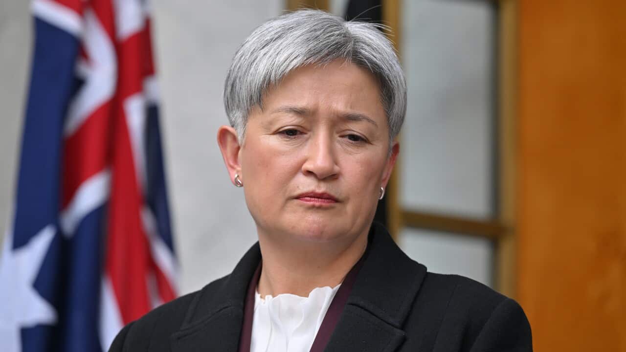 Penny Wong wearing a black coat and frowning