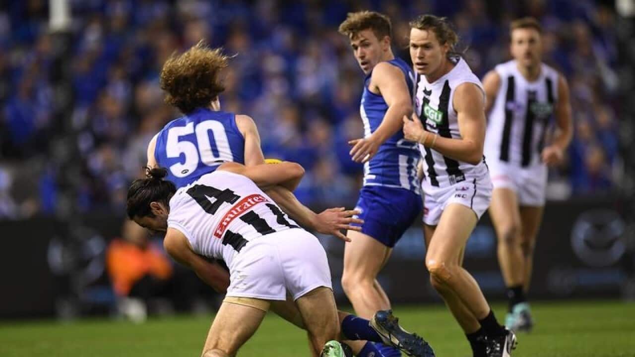 Brodie Grundy of the Magpies tackles Ben Brown of the Kangaroos.