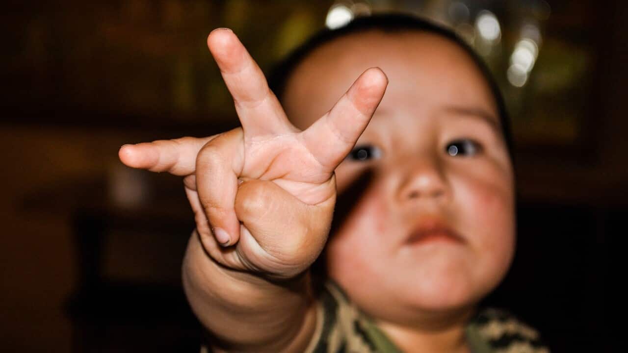 A child is rasing three fingers
