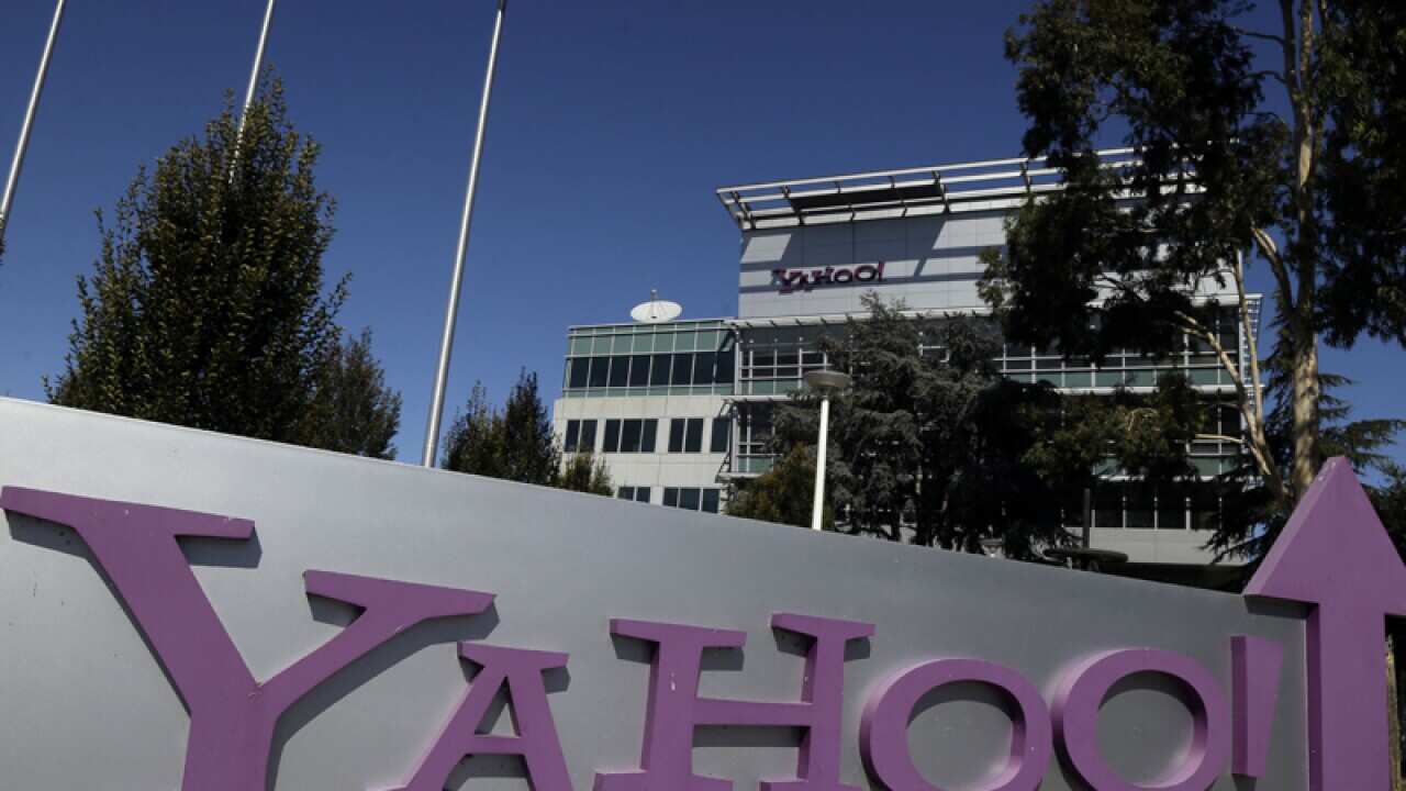 A person views the new Yahoo company logo