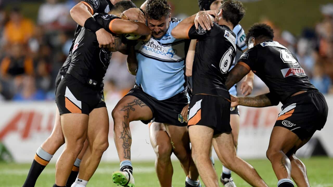 Andrew Fifita of the Sharks forces his way through the Tigers defence