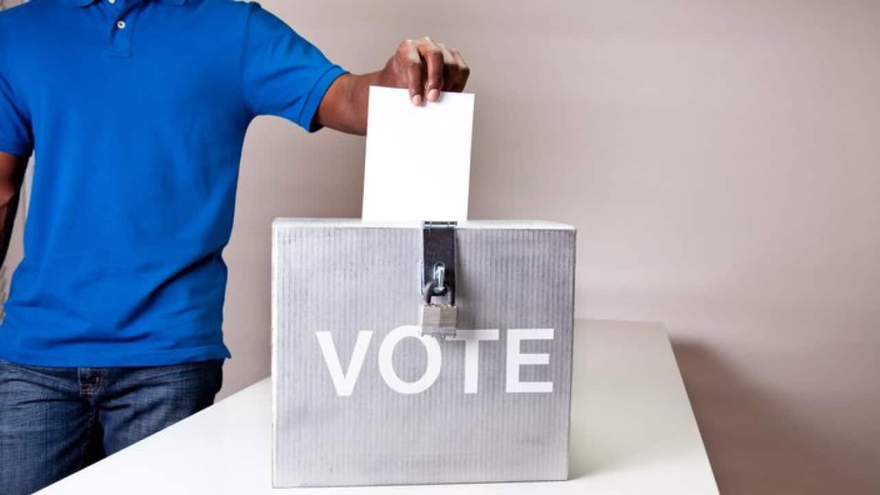 African descent man casting his vote. Ballot box.