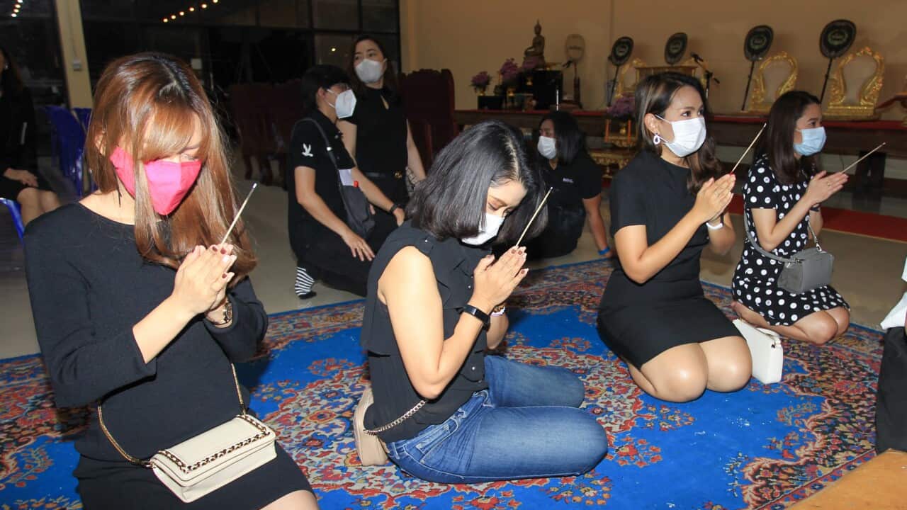 People attend a funeral ceremony for a Thai man aged 35 who was suffering from dengue fever and later was infected with Covid-19