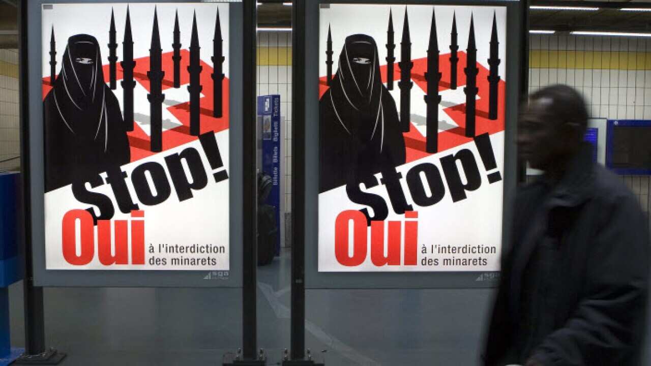 woman wearing a burqa against a background of a Swiss flag